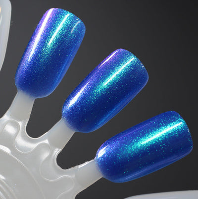 Cheers to 10 Years by Dam Nail Polish, royal blue base showing green-to-purple duochrome shimmer flash, swatch stick