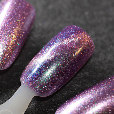 Moonlight Mist by Dam Nail Polish, dark purple holographic shimmer magnetic with pink magnetic streak and green-blue shimmer shift, swatch stick