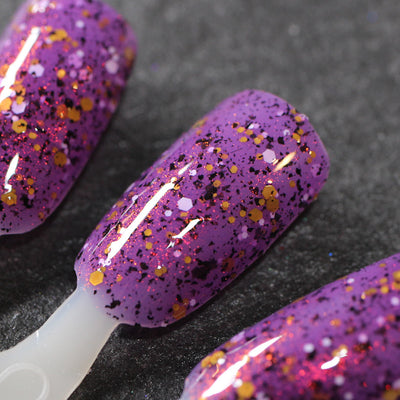 AHHHH The Flakies by Dam Nail Polish, purple jelly with black flakies, red-orange shimmer, and mixed gold and white hex glitter, swatch stick