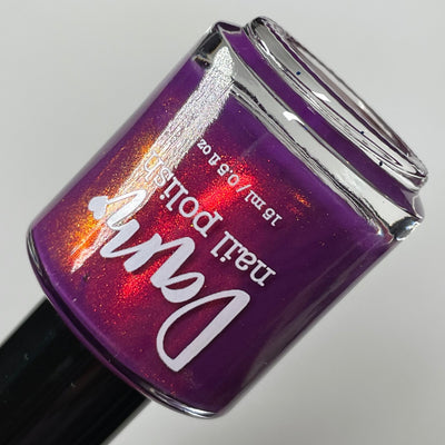 Dark Eyes Blossom by Dam Nail Polish, deep violet-purple shimmer with red-to-orange shifting shimmer highlights, bottle standalone product shot