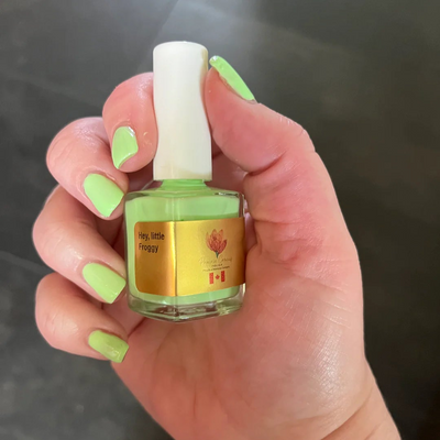 Hey, Little Froggy by Prairie Crocus Polish, bright pale lime green creme, bottle held in a light hand