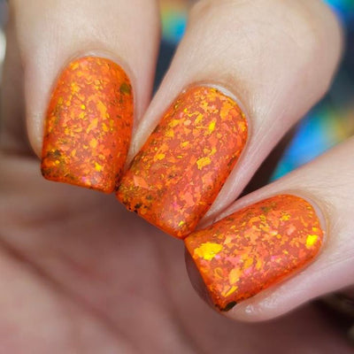 Sauron's Eye by Chamaeleon Nails, fiery orange jelly with golden copper and copper-to-green UCC multichrome flakies in natural daylight, on a light skin tone hand