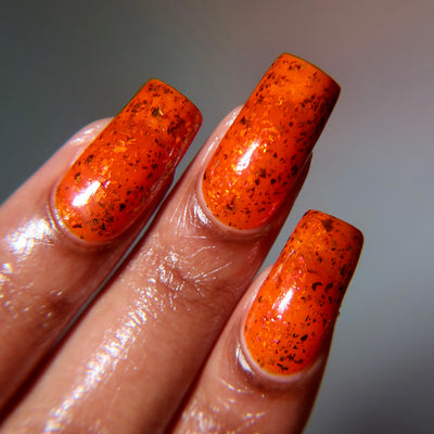 Sauron's Eye by Chamaeleon Nails, fiery orange-red jelly with dark copper-brown and warm orange iridescent ultrachrome flakies, on a light-medium skin tone hand