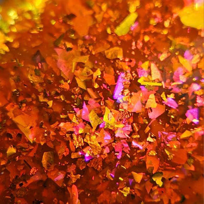 Sauron's Eye by Chamaeleon Nails, macro close-up of densely packed copper-to-pink-to-green UCC flakies with magenta and gold iridescent shift in fiery orange jelly base