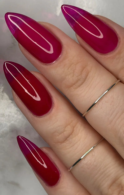 Bloodbelly Jelly by Starrily, deep burgundy red sheer jelly with glassy depth and specular highlights, on a light-medium skin tone hand