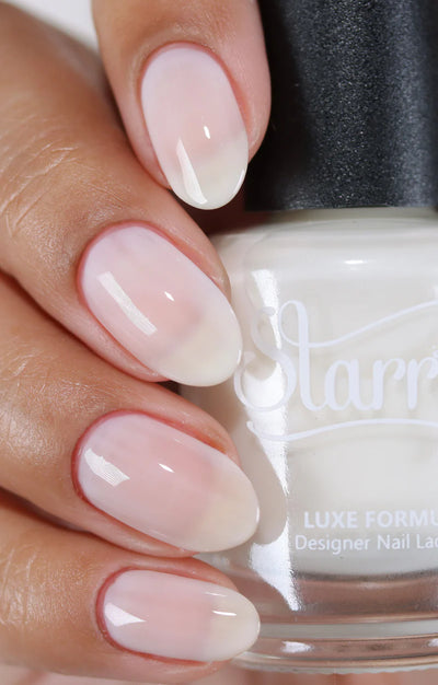 Ghost Jelly by Starrily, sheer milky white jelly with buildable coverage and brighter tip concentration, bottle held in a medium skin tone hand