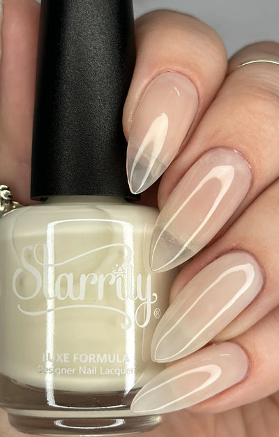 Ghost Jelly by Starrily, sheer warm nude-white jelly with natural nail showing through, bottle held in a light skin tone hand