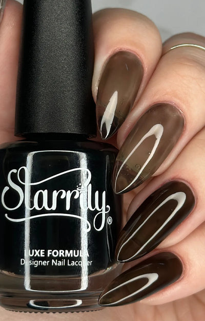 Immortal Jelly by Starrily, black sheer jelly showing buildable range from translucent warm brown to near-black opacity, bottle held in a light skin tone hand