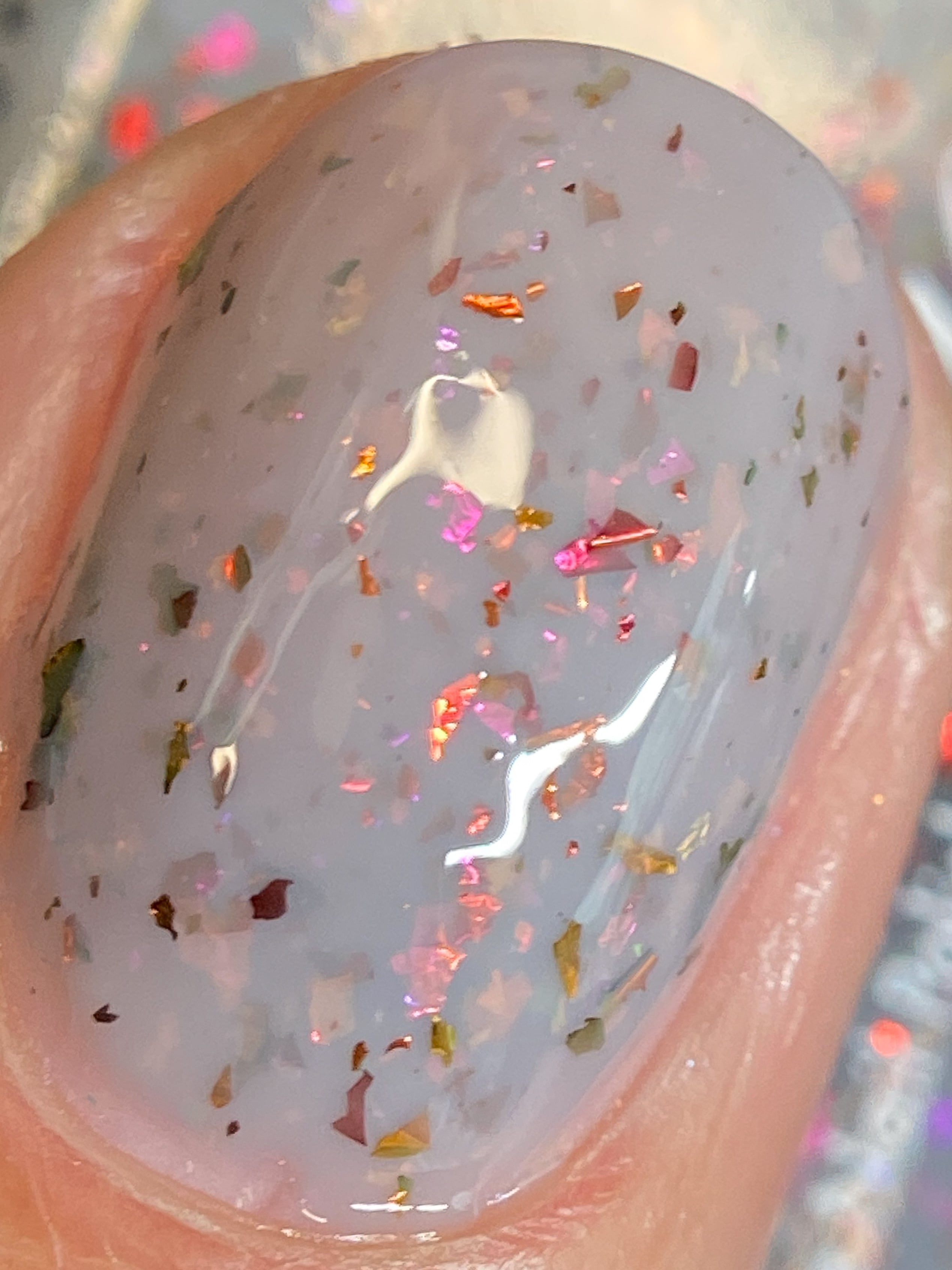Cadillacquer Daydreaming grey red chameleon iridescent crelly nail polish, macro single-nail swatch, light skin, bright daylight lighting