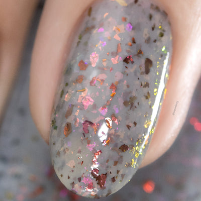 Cadillacquer Daydreaming grey red chameleon iridescent crelly nail polish, macro single-nail swatch, light skin, studio lighting