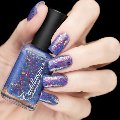 Cadillacquer Don't Worry purple pink chameleon iridescent crelly nail polish, bottle held with five-nail swatch, light skin, studio lighting