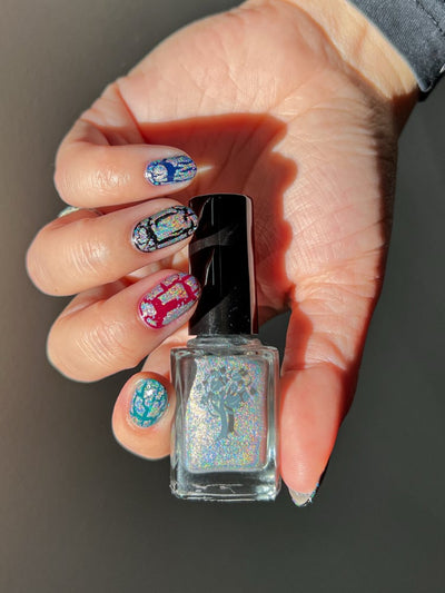 Castle of Glass (Crackle) by Danglefoot Nail Polish, silver holographic crackle topper bottle held in a light hand