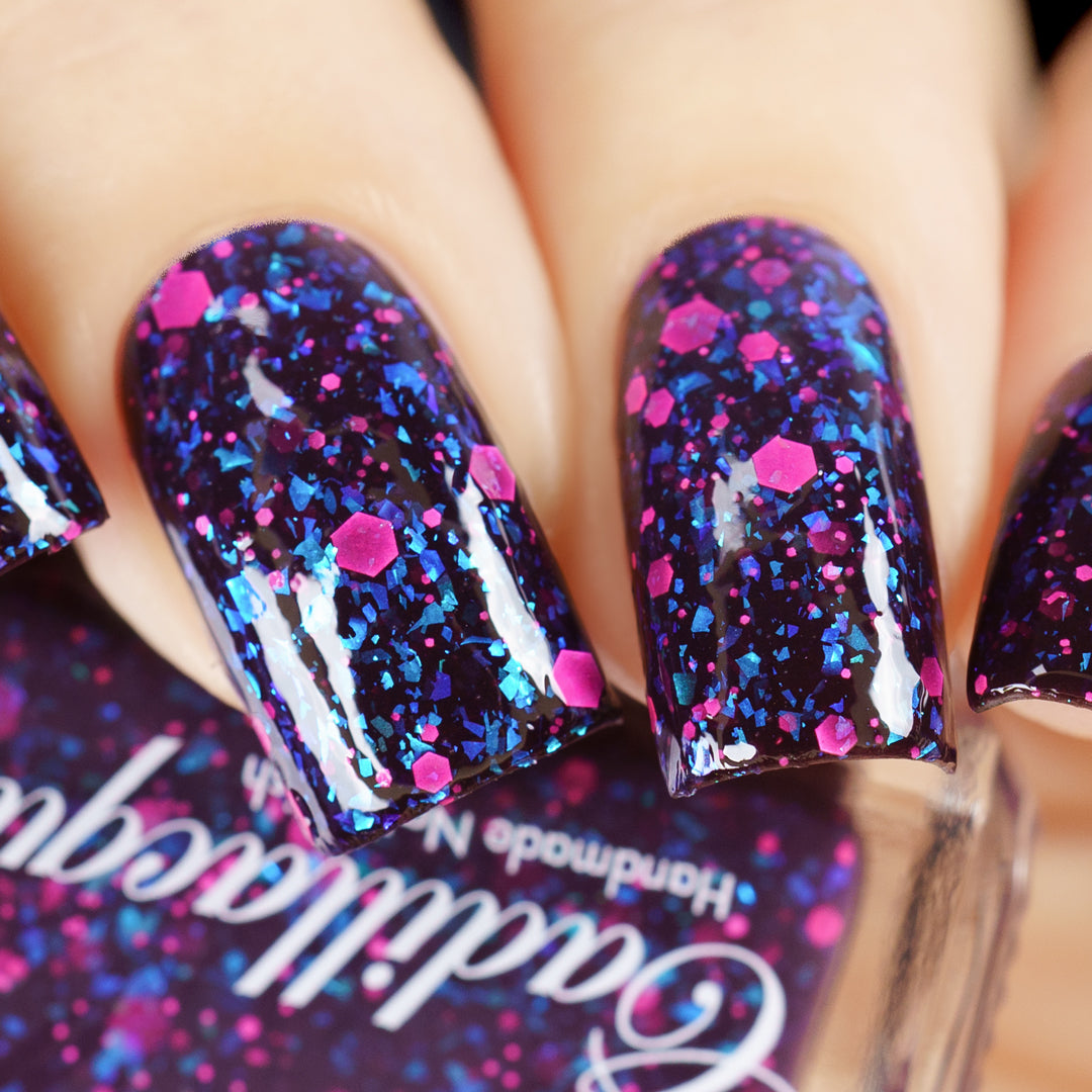 Thermal glitter-and-flake Cadillacquer nail polish in What Lurks Within, shown as a swatch on five squoval nails in the cold state, a near-black eggplant-purple base loaded with cyan-to-cobalt iridescent flakes and matte neon-pink hexagonal and micro glitter, on light skin tones, studio lighting, swatched by @yyulia_m