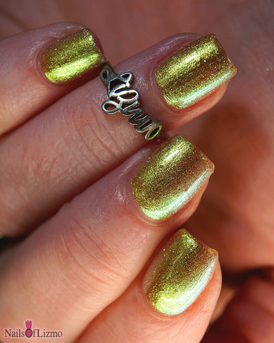 Flame On by Danglefoot Nail Polish, gold-green duochrome shimmer on a light-medium skin tone hand