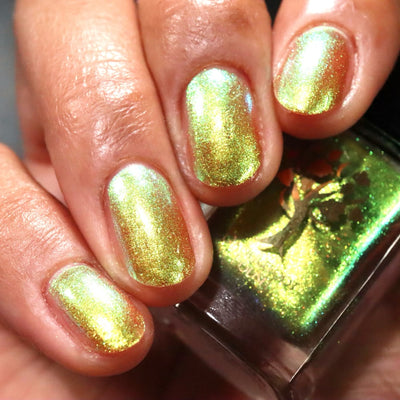 Flame On by Danglefoot Nail Polish, gold-green duochrome shimmer on a light-medium skin tone hand