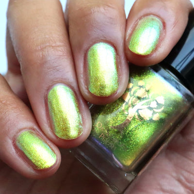 Flame On by Danglefoot Nail Polish, gold-green duochrome shimmer bottle held in a medium hand