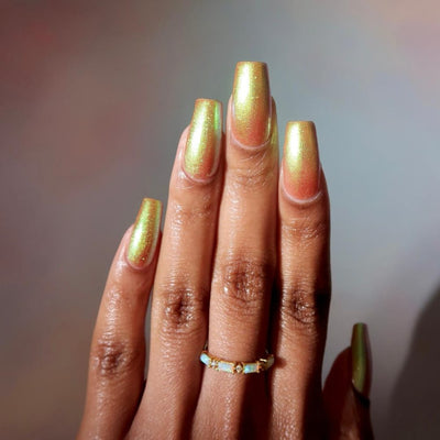 Flame On by Danglefoot Nail Polish, gold-green duochrome shimmer on a deep skin tone hand