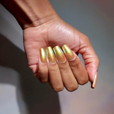 Flame On by Danglefoot Nail Polish, gold-green duochrome shimmer on a medium-deep skin tone hand
