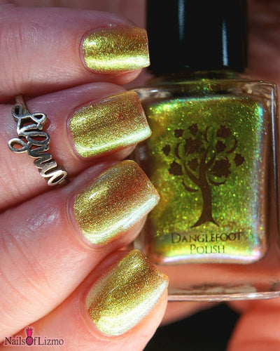 Flame On by Danglefoot Nail Polish, gold-green duochrome shimmer bottle held in a light hand