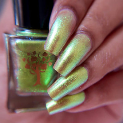 Flame On by Danglefoot Nail Polish, gold-green duochrome shimmer bottle held in a light-medium hand