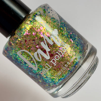 Ayla the Scoliosis Dolphin by Dam Nail Polish, blue-gold multichrome flakie showing gold, pink, and green-to-blue shifting flakies under studio light, bottle standalone product shot