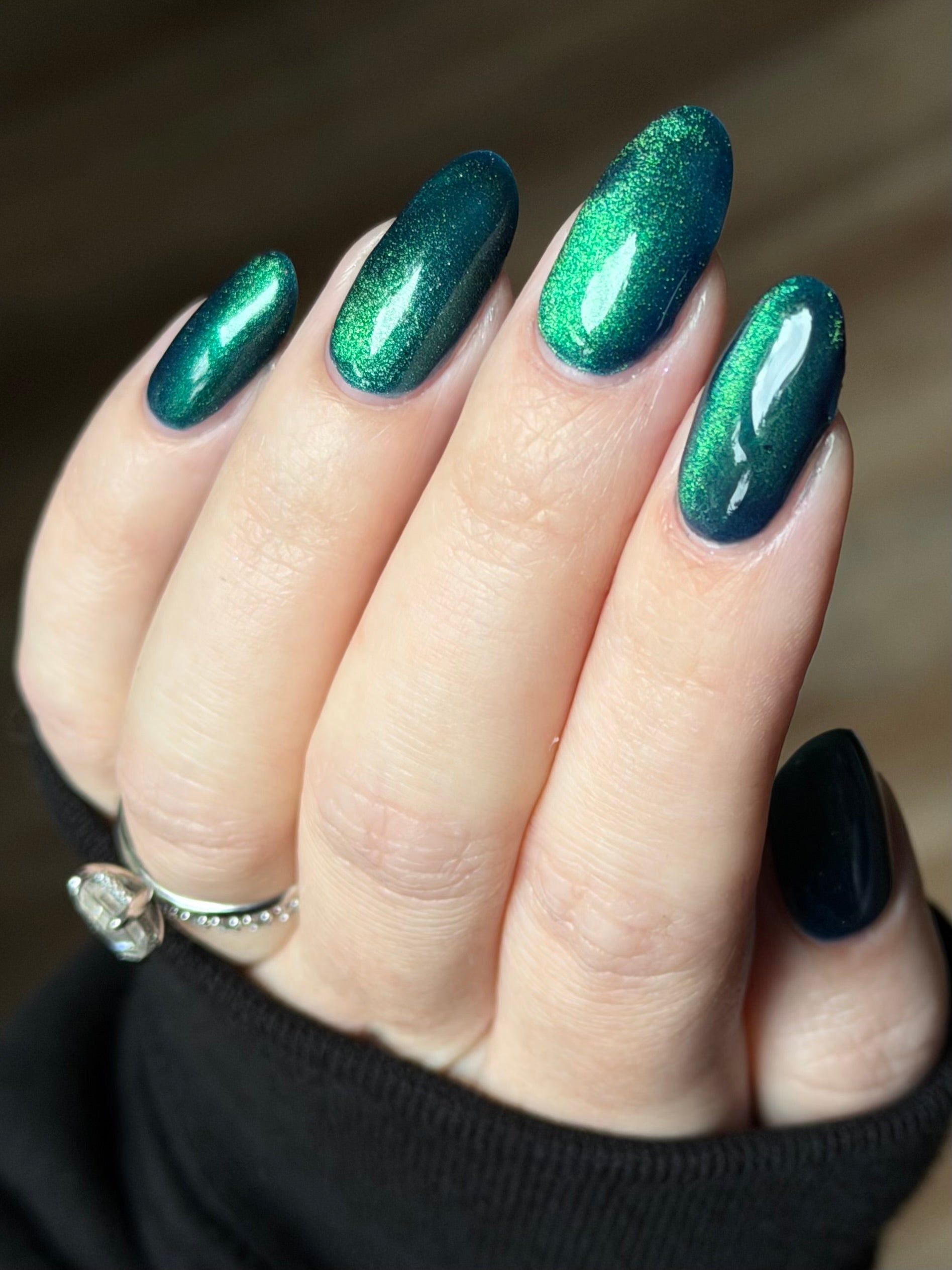 Do-Nuts by Glitch Lacquer, deep blue jelly, green-to-teal-to-blue magnetic cat-eye, on light skin tone almond nails