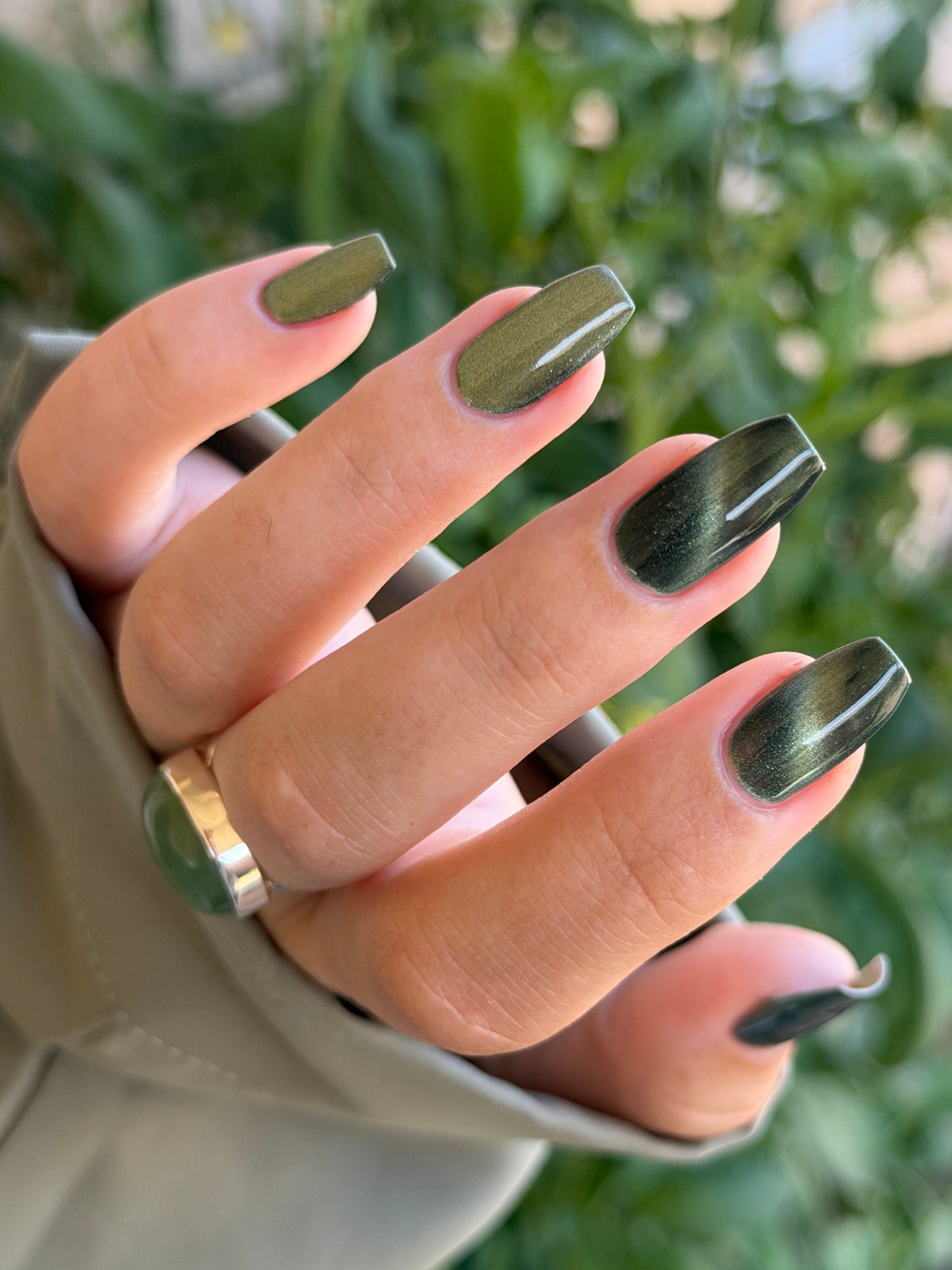 AUREA by Glitch Lacquer, blackened green base, greenish-gold magnetic cat-eye, on light skin tone coffin nails
