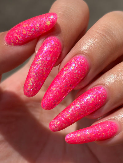 Be Gay, Do Crime by Glitch Lacquer, holo glitter and rainbow flake topper over neon pink, on light-medium skin tone nails