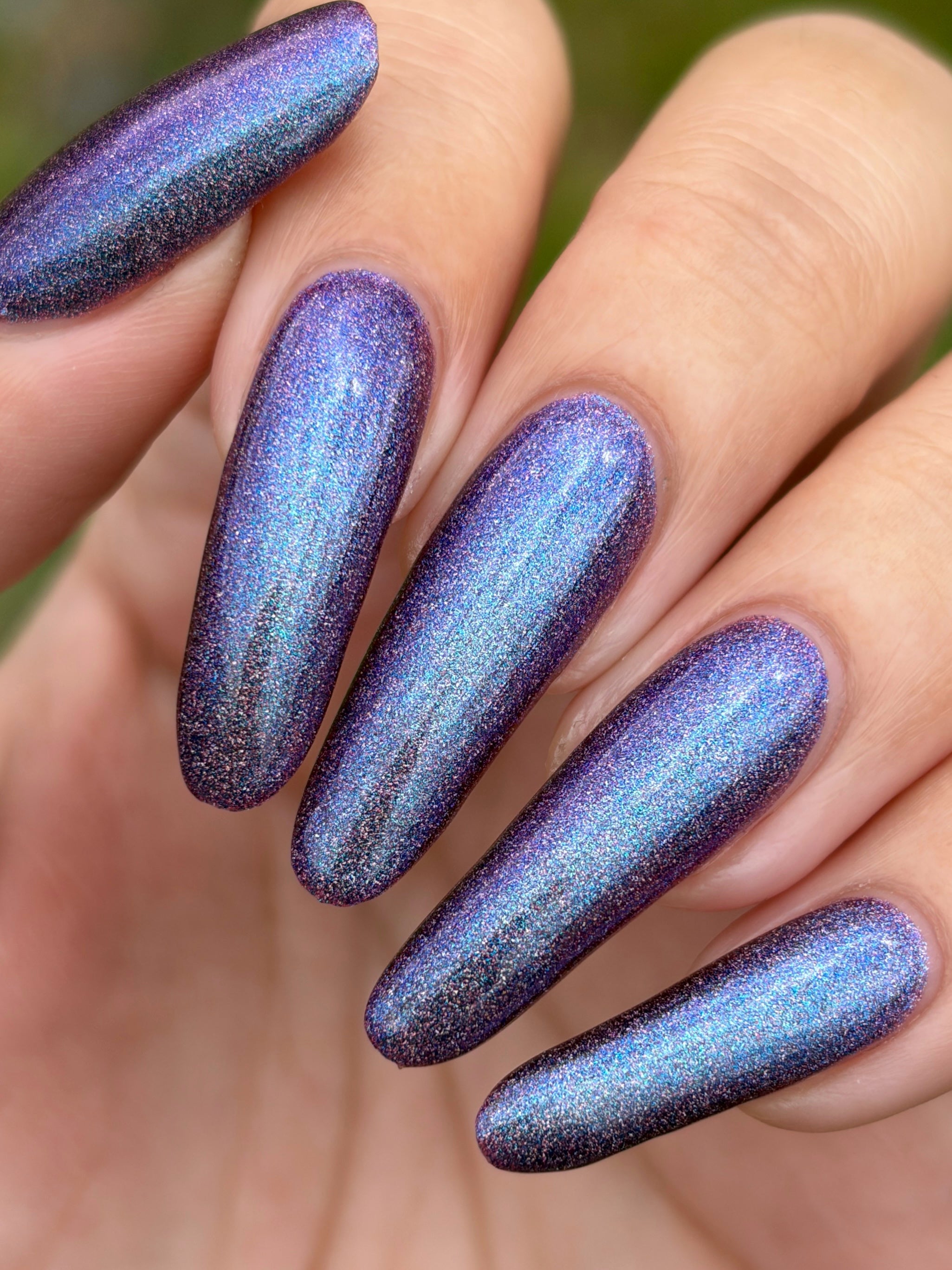 Bi Panic by Glitch Lacquer, magenta jelly, blue-to-purple glow, linear holographic, on light skin tone almond nails