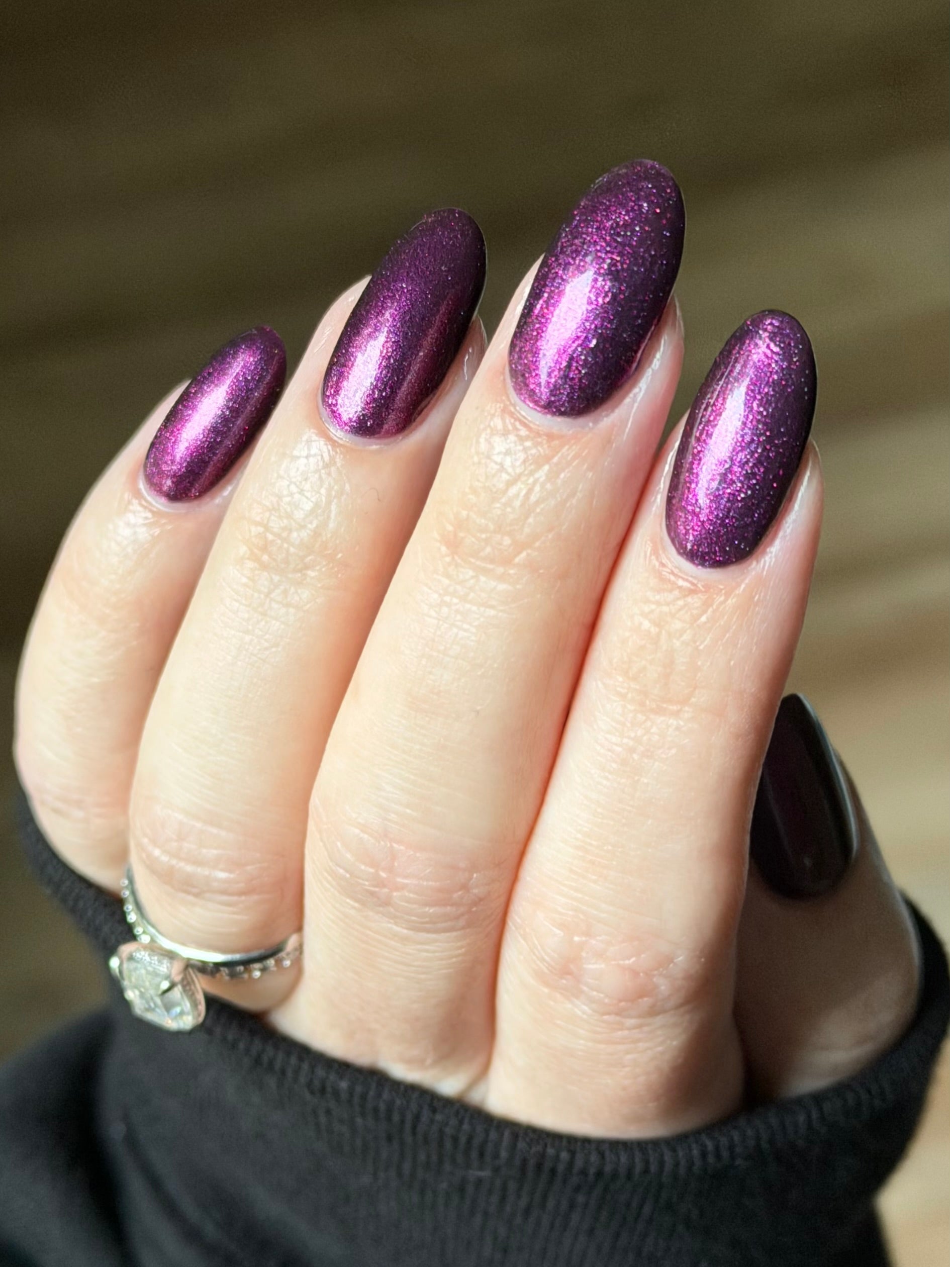 Sister Outsider by Glitch Lacquer, blackened purple jelly with magenta-purple sparkle, on light skin tone almond nails