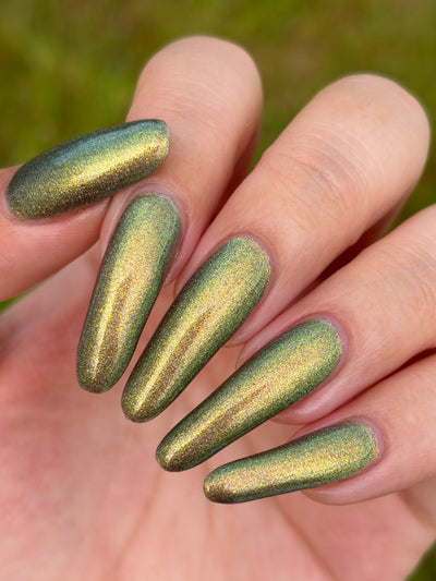 Safe House Glow by Glitch Lacquer, grey base, gold-to-teal multichrome shift, holo shimmer, on light-medium skin tone nails