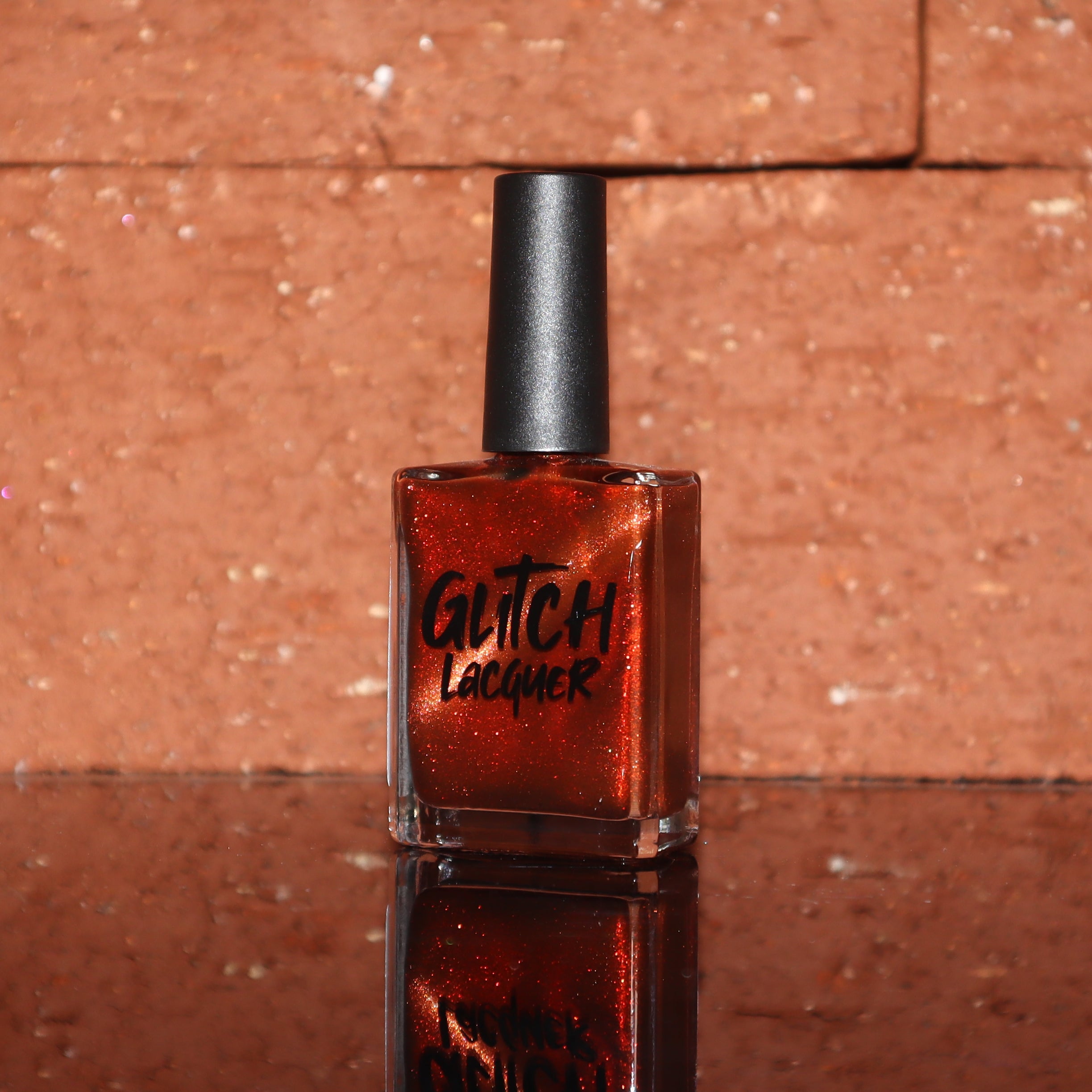 Marigold by Glitch Lacquer, burnt orange jelly with red shimmer and orange-to-gold magnetic, bottle
