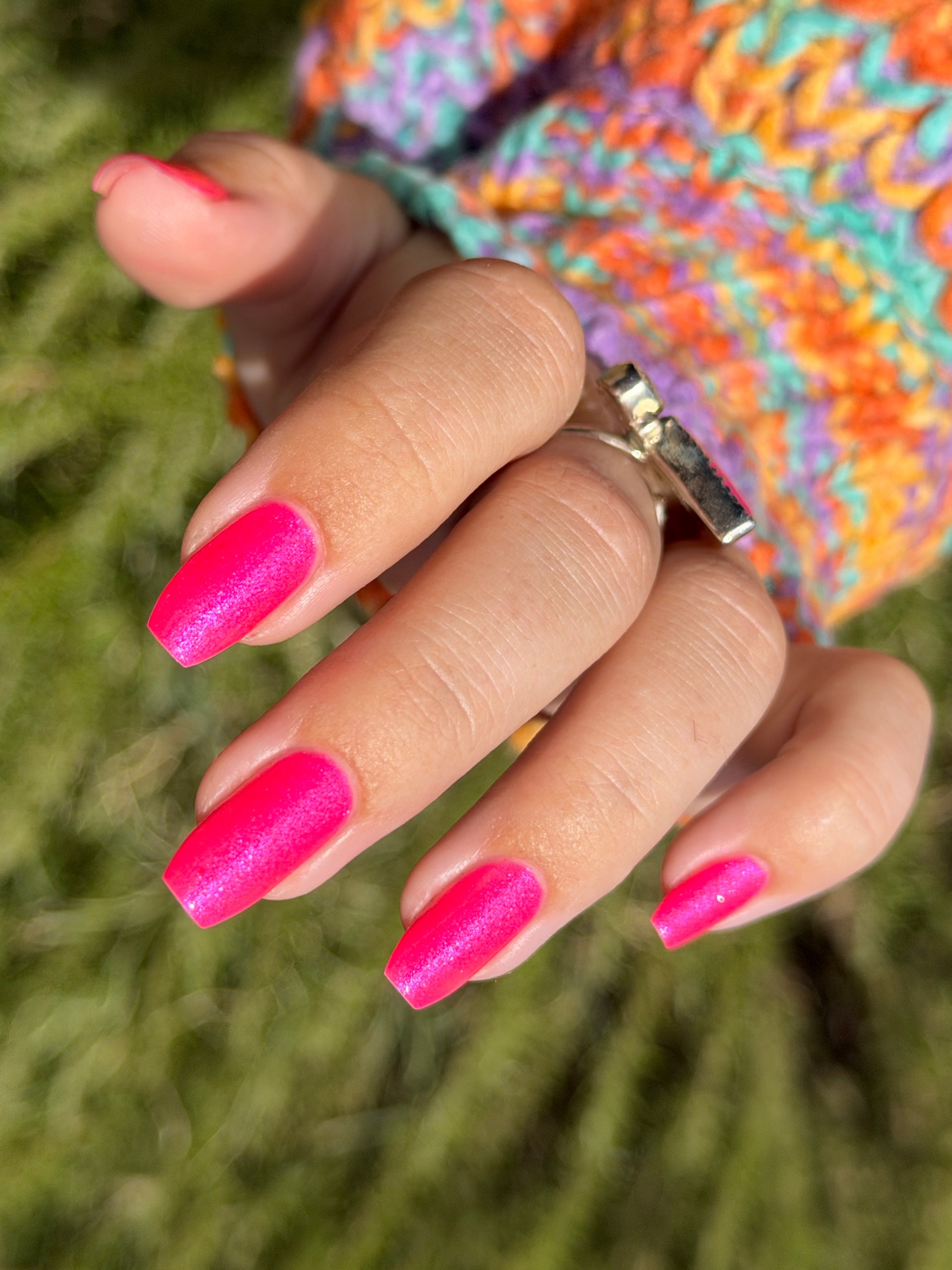 ACT UP by Glitch Lacquer, neon pink crelly with cool-toned pink sparkle, on light-medium skin tone coffin nails