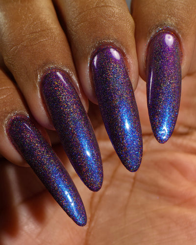Bi Panic by Glitch Lacquer, magenta jelly, blue-to-purple glow, linear holographic, on deep skin tone stiletto nails