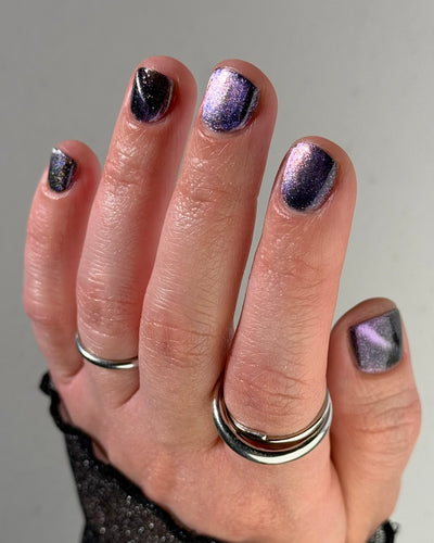 Lavender Menace by Glitch Lacquer, black jelly, purple-blue magnetic cat-eye, purple sparkle, on light skin tone square nails