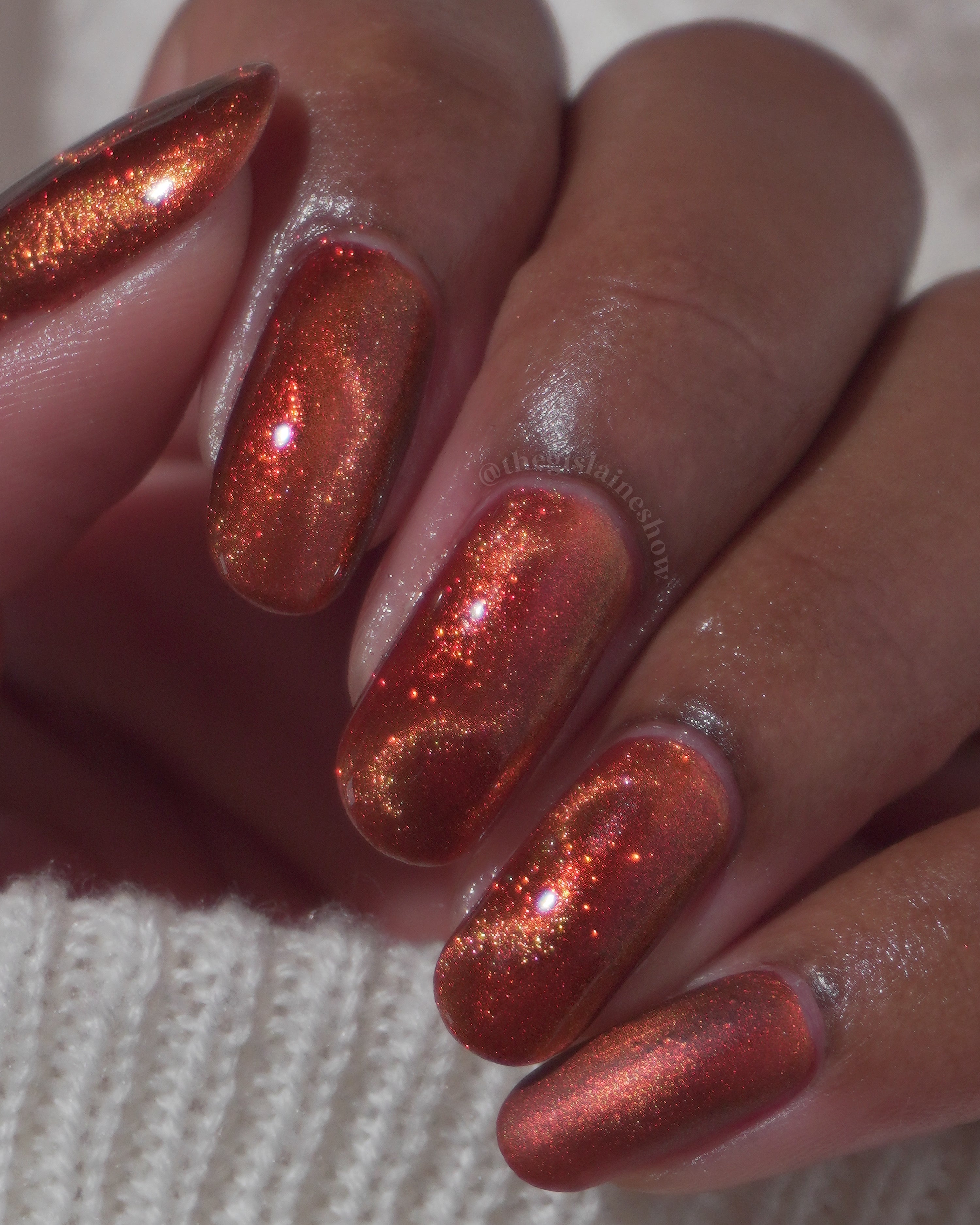 Marigold by Glitch Lacquer, burnt orange jelly, red shimmer, orange-to-gold magnetic, on medium-deep skin tone nails