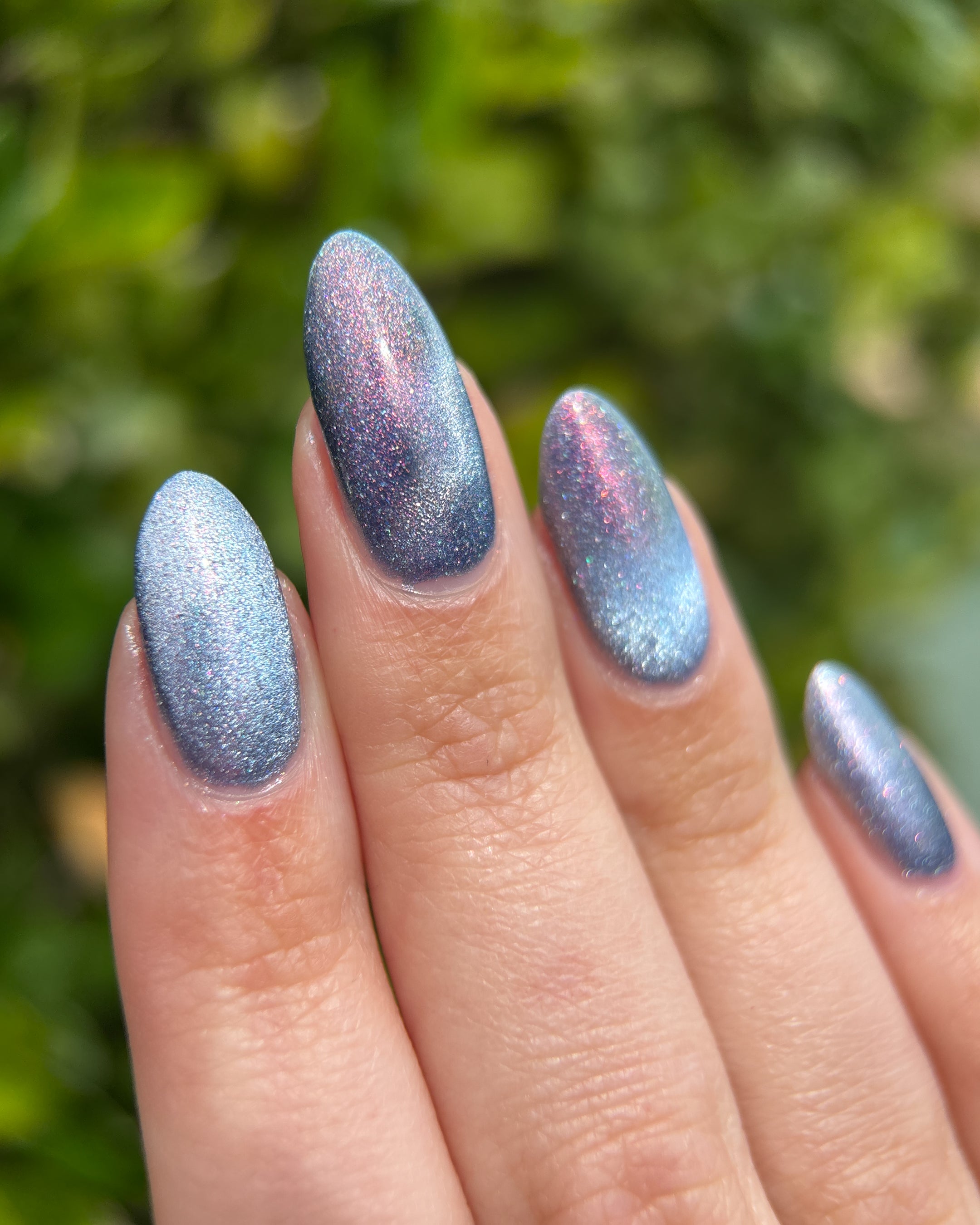 Protect the Dolls by Glitch Lacquer, blue jelly, pink-orange-green shimmer, silver magnetic, on light skin tone nails