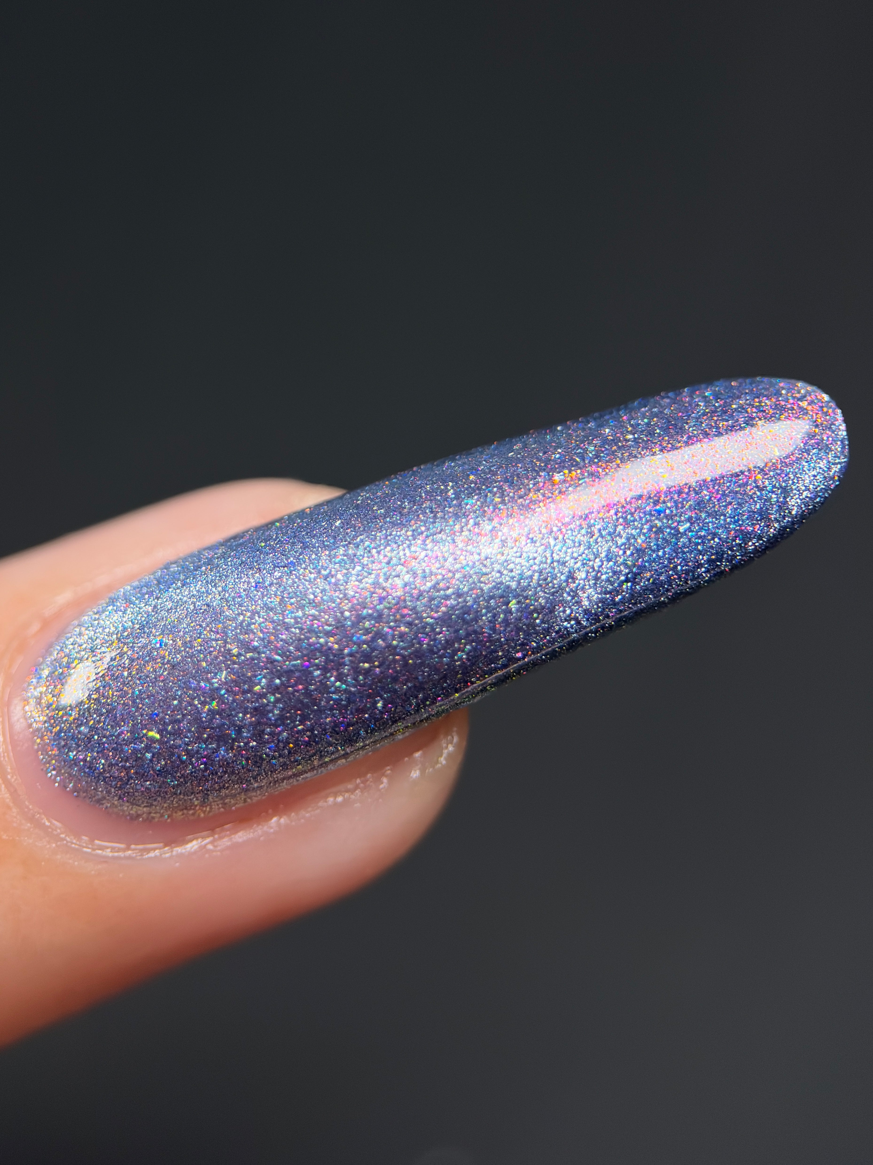 Protect the Dolls by Glitch Lacquer, blue jelly with pink-orange-green shimmer and holo dusting, macro on light skin tone