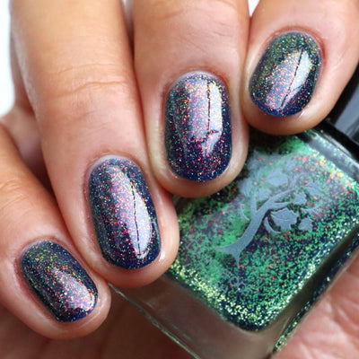 Mr Luthoooor by Danglefoot Nail Polish, blue-green multichrome reflective shimmer glitter on a light-medium skin tone hand