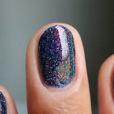 Mr Luthoooor by Danglefoot Nail Polish, blue-green multichrome reflective shimmer glitter on a light-medium skin tone hand