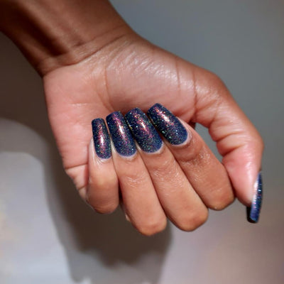 Mr Luthoooor by Danglefoot Nail Polish, blue-green multichrome reflective shimmer glitter on a medium-deep skin tone hand