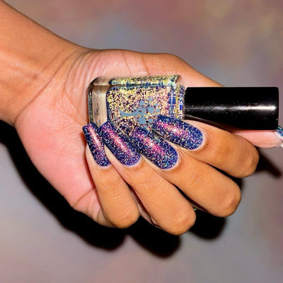 Mr Luthoooor by Danglefoot Nail Polish, blue-green multichrome reflective shimmer glitter bottle held in a medium-deep hand