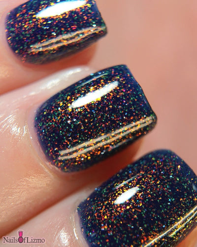 Mr Luthoooor by Danglefoot Nail Polish, blue-green multichrome reflective shimmer glitter on a light skin tone hand