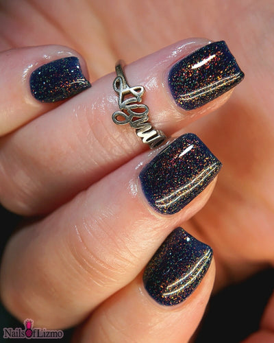 Mr Luthoooor by Danglefoot Nail Polish, blue-green multichrome reflective shimmer glitter on a light skin tone hand