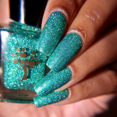 Mutant and Proud by Danglefoot Nail Polish, green-teal holographic reflective glitter flakie on a medium skin tone hand