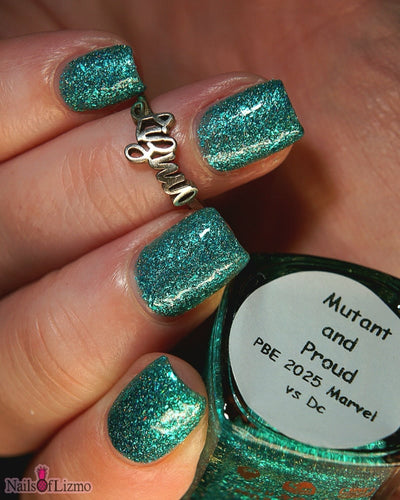 Mutant and Proud by Danglefoot Nail Polish, green-teal holographic reflective glitter flakie on a light-medium skin tone hand