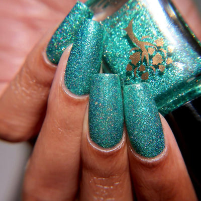 Mutant and Proud by Danglefoot Nail Polish, green-teal holographic reflective glitter flakie on a medium skin tone hand