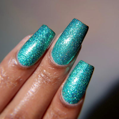 Mutant and Proud by Danglefoot Nail Polish, green-teal holographic reflective glitter flakie on a light-medium skin tone hand