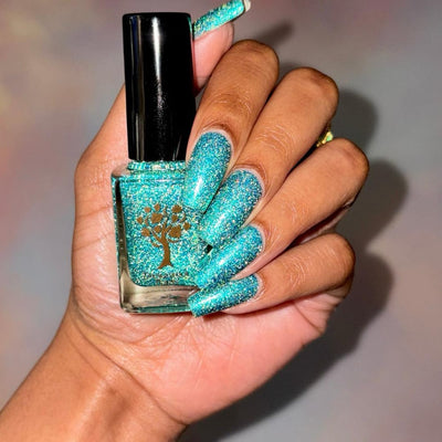 Mutant and Proud by Danglefoot Nail Polish, green-teal holographic reflective glitter flakie bottle held in a medium-deep hand