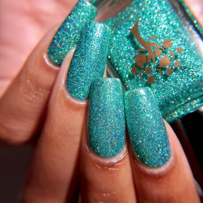 Mutant and Proud by Danglefoot Nail Polish, green-teal holographic reflective glitter flakie on a light-medium skin tone hand
